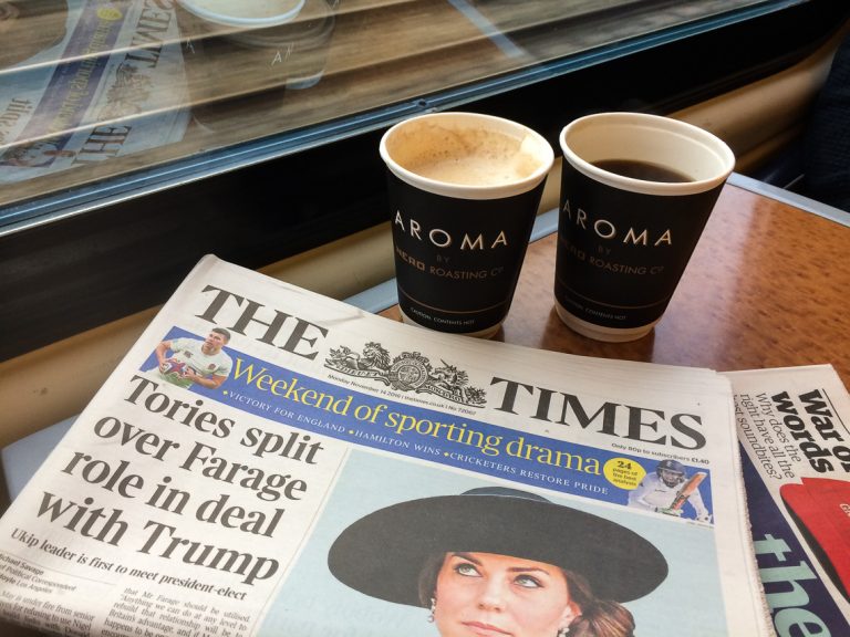Vi har aviser og kaffe og er om bord på toget fra London til Holyhead.