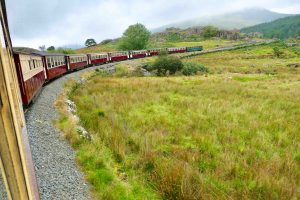Welsh Highland Railway snor seg gjennom landskapet, på vei til verdensarvbyen Caernarfon nord i Wales