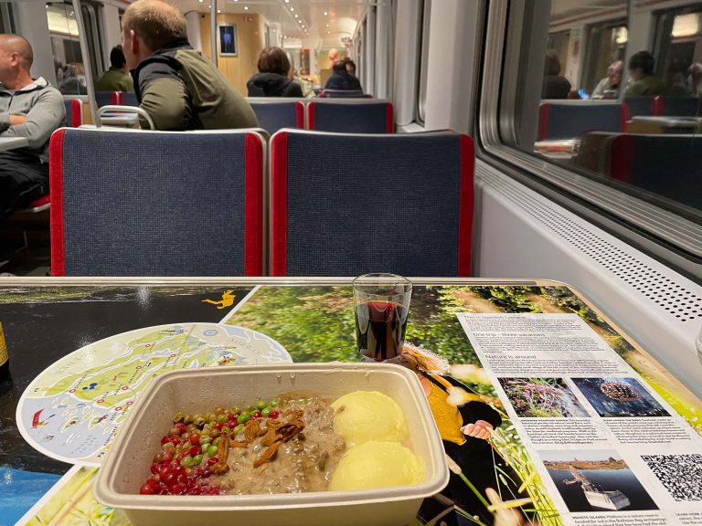 Gräddstuvad renskav, potatismos og et plastglass med rødvin i restaurantvognen på Tåg 94 fra Stockholm til Narvik.