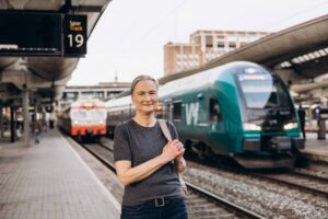 Foto av togblogger Sigrid Elsrud foran tog på Oslo S.