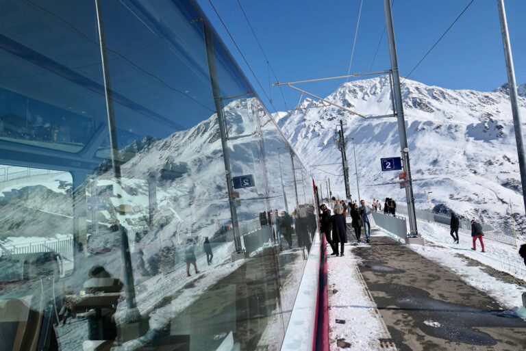 Her har turisttoget Glacier Express tatt en pause i bratthenget ovenfor Andermatt. Mange har lyst til å reise med dette toget eller med det enda mer kjente søstertoget Bernina Express, men interrailere kan også reise langs de samme sporene med andre tog uten å bestille plassreservasjon.
