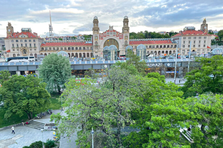 Jernbanestasjonen Praha hlavní nádraží fotografert fra et hotellrom på Exe City Park. Her ser vi litt av parken vi kommer ut til fra den nye delen av stasjonen. Fin måte å møte Praha på, men husk også en visitt opp i det gamle stasjonsbygget! (Foto: Togbloggen)
